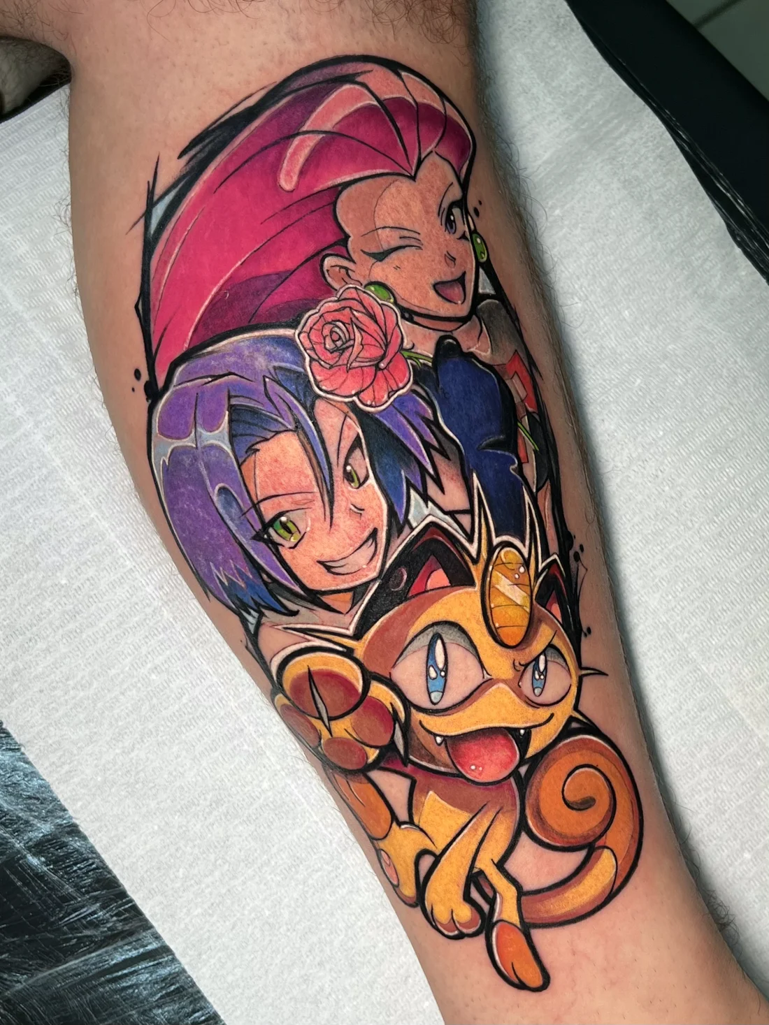 Tatuagem colorida da Equipe Rocket e Meowth de Pokémon feita pela Jess Zanatta