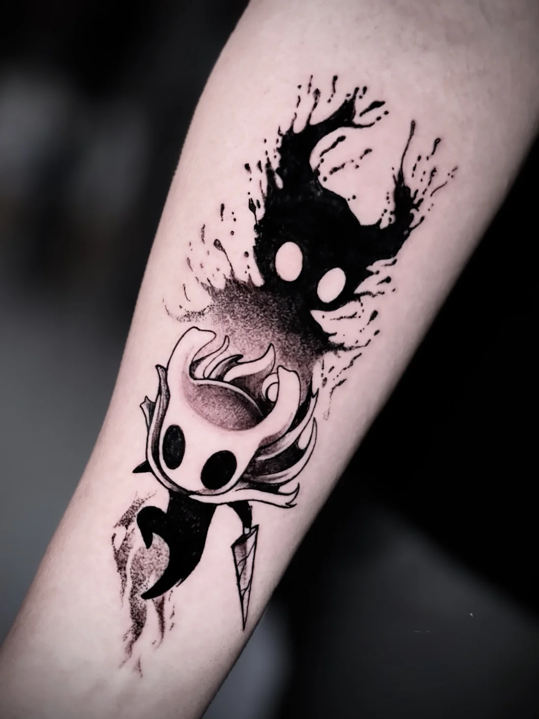 Tatuagem blackwork do personagem de Hollow Knight feita pela Jess Zanatta