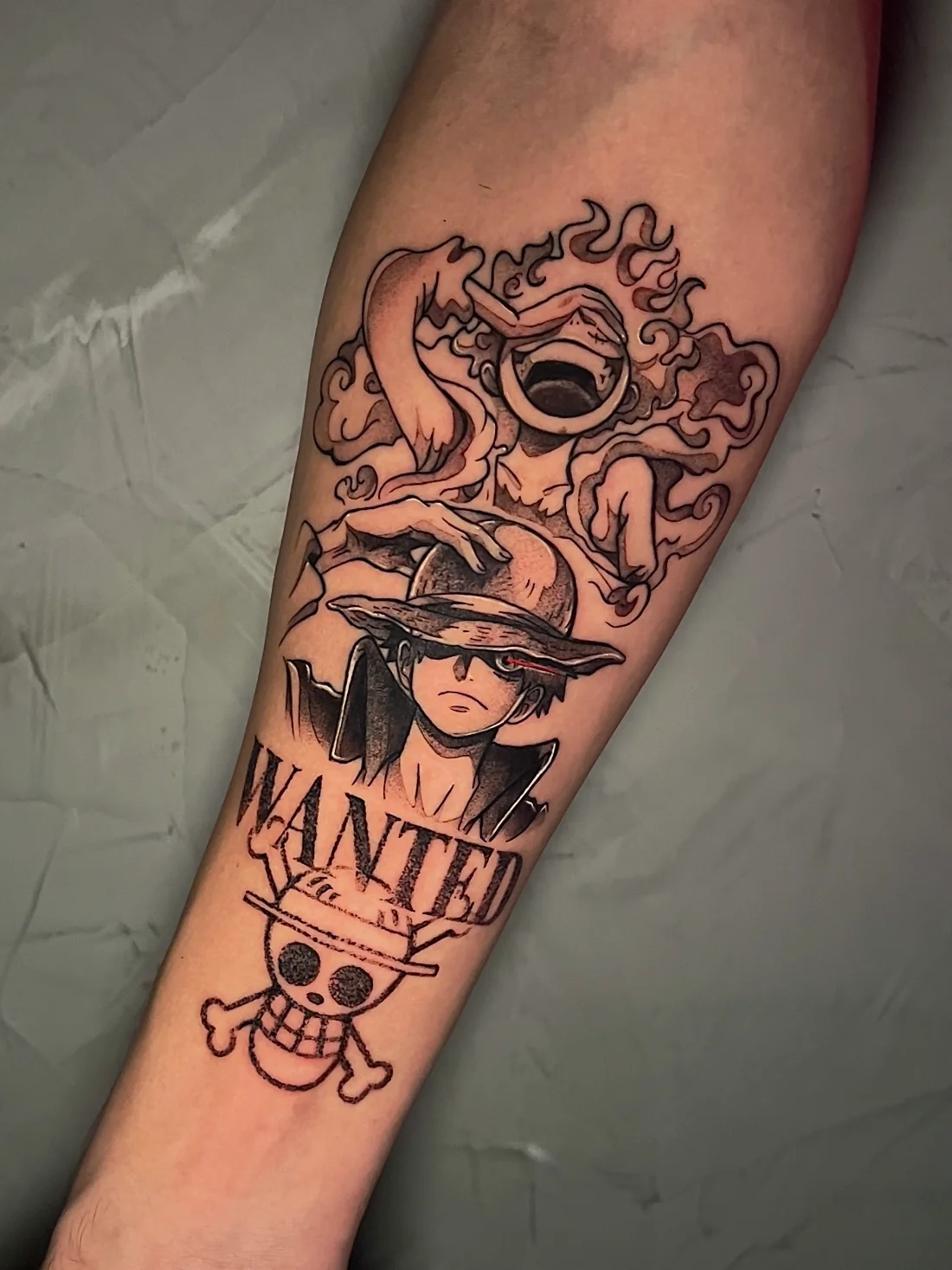 Tatuagem blackwork do Luffy de One Piece com cartaz de procurado feita pela Jess Zanatta