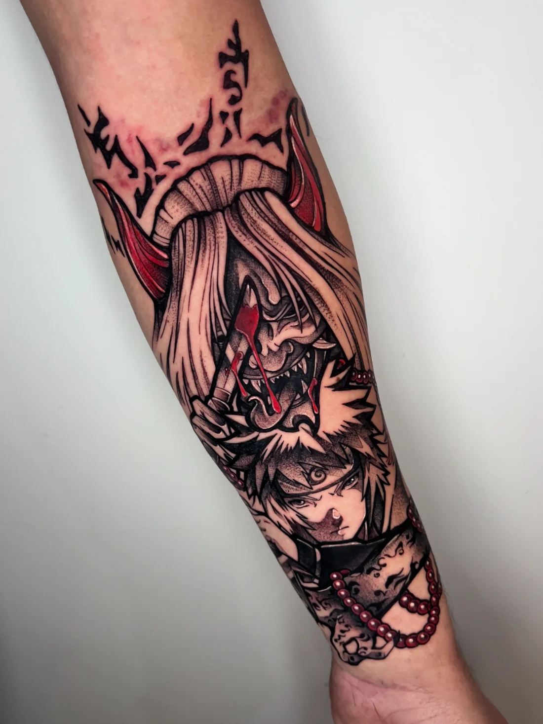 Tatuagem de anime blackwork de máscara oni com personagem de Naruto feita pela Jess Zanatta em São Bernardo do Campo